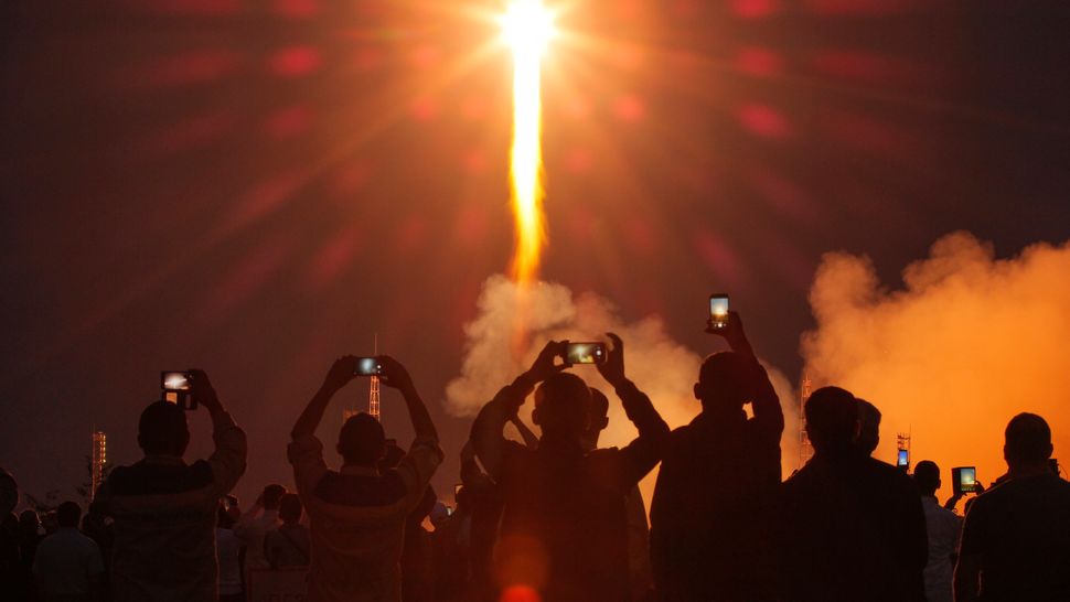 Άνθρωποι παρακολουθούν την εκτόξευση του πυραύλου Soyuz MS-15, με τη κάψουλα που μεταφέρει το νέο πλήρωμα στο Διεθνή Διαστημικό Σταθμό στο Καζακστάν.