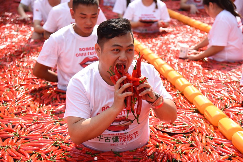 Τουρίστες συμμετέχουν σε αγώνα φαγητού με καυτερές πιπεριές στο Song Dynasty Town την Κυριακή, στην επαρχία Zhejiang της Κίνας.