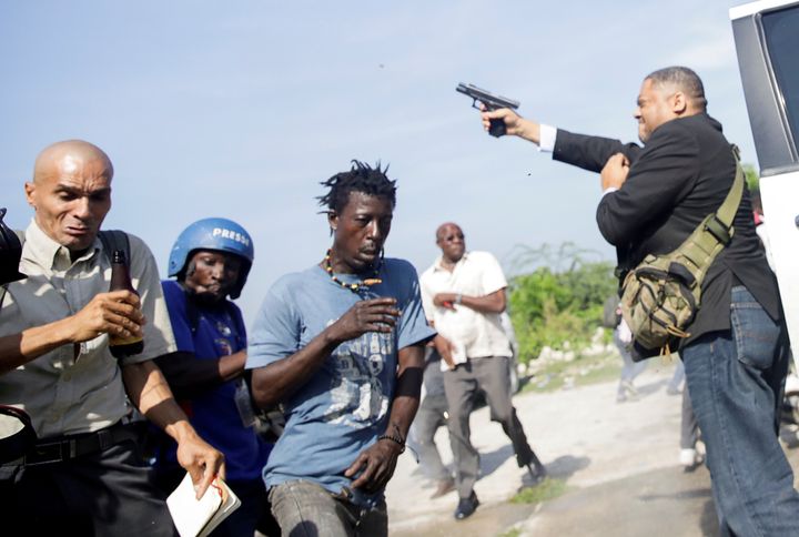 People run as Haiti's Senator Jean Marie Ralph Fethiere (PHTK) fires a gun in the air, injuring Chery Dieu-Nalio, a photographer for Associated Press, while facing opposition supporters in the parking lot of the Haitian Parliament and Senate, as the government attempted to confirm the appointment of nominated Prime Minister Fritz William Michel, in Port-au-Prince, Haiti September 23, 2019. REUTERS/Andres Martinez Casares TPX IMAGES OF THE DAY