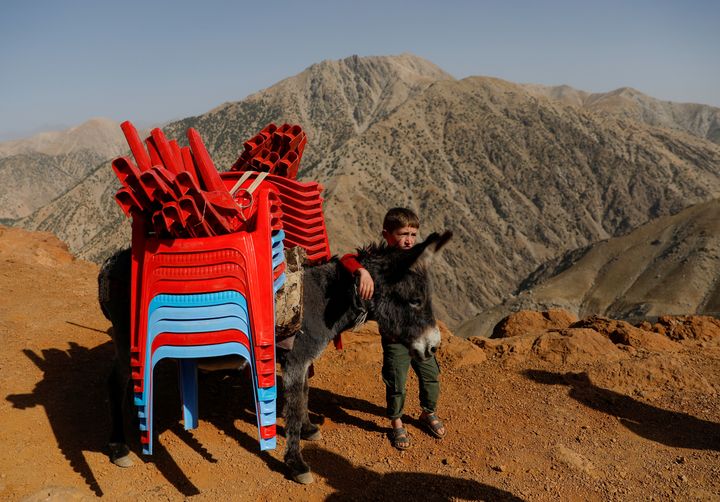 An Afghan boy stands with a donkey loaded election material, to be transported to polling stations which are not accessible by road, on a donkey in Shutul, Panjshir province, Afghanistan September 27, 2019.REUTERS/Mohammad Ismail TPX IMAGES OF THE DAY