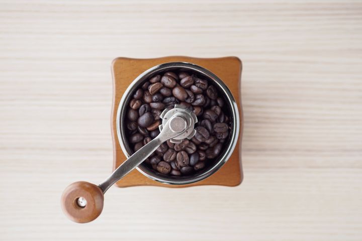 A burr grinder uses two revolving surfaces to basically crush beans a few at a time.