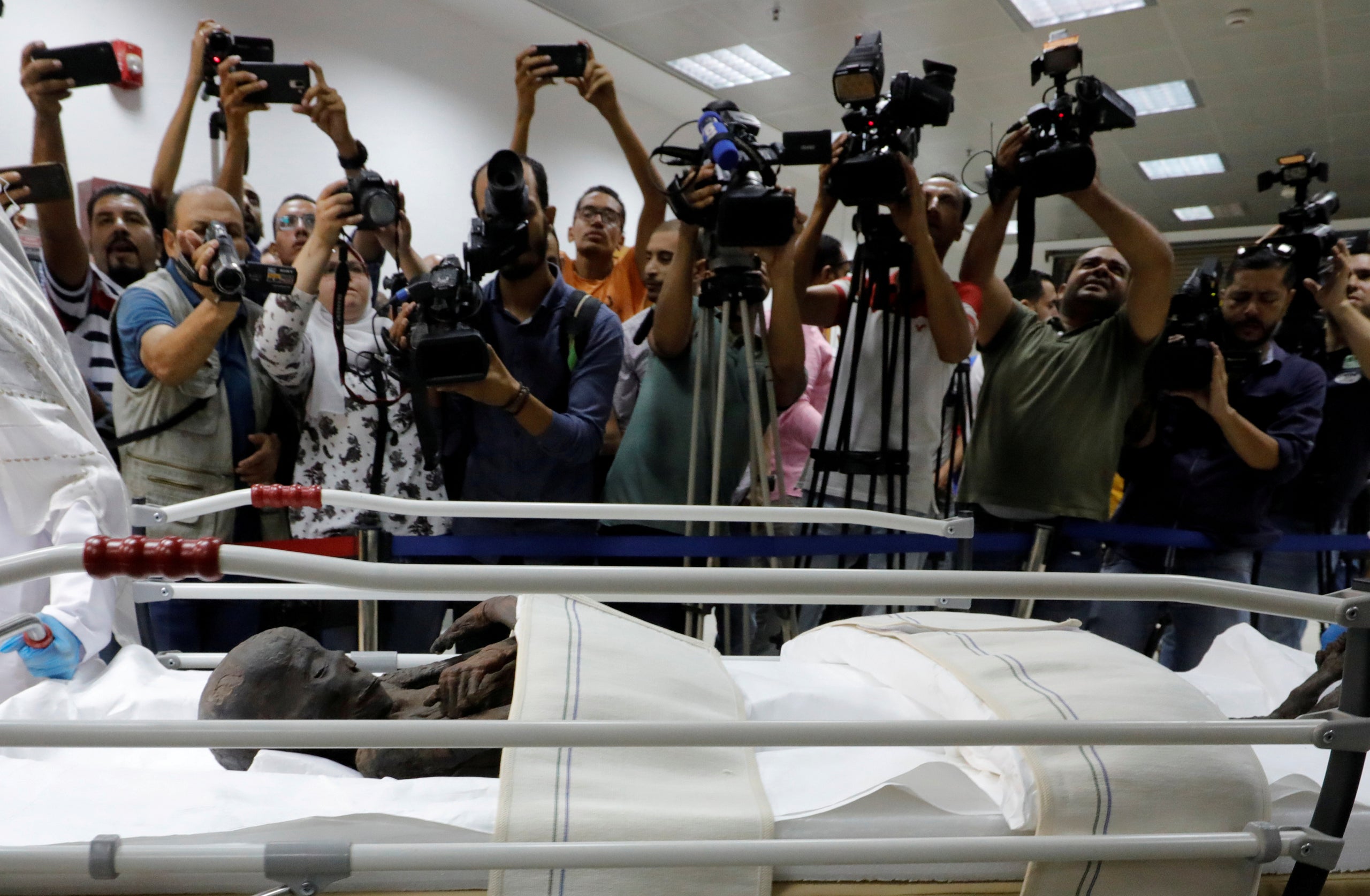 Members of the media are seen in front of the pharaonic mummy of Sennedjem after it was removed from his coffin at the Nation