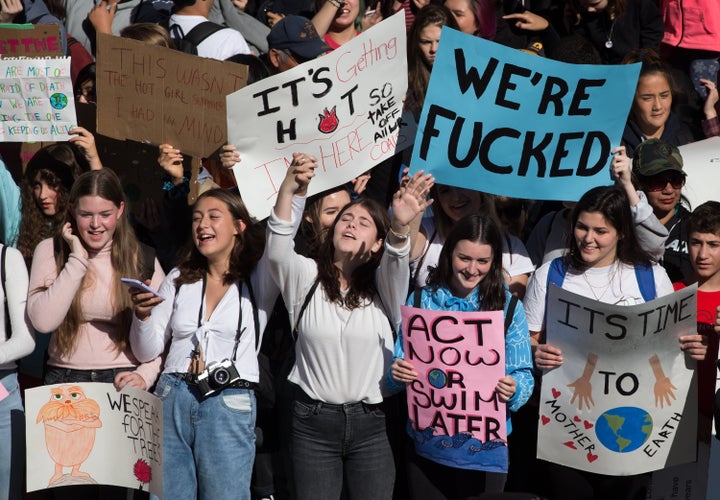 Young people hold signs with messages like "Act now or swim later" and "We're f***ed" outside Vancouver City Hall before marching downtown for a climate strike in Vancouver on Sept. 27, 2019.
