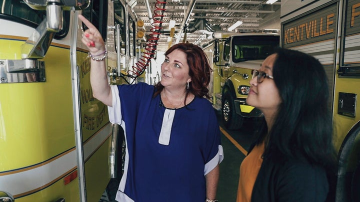 Kings–Hants Conservative candidate Martha MacQuarrie points to the custom decal on a firetruck parked in the Kentville, N.S., fire hall bay dedicated to her late husband and longtime volunteer firefighter, Brian.