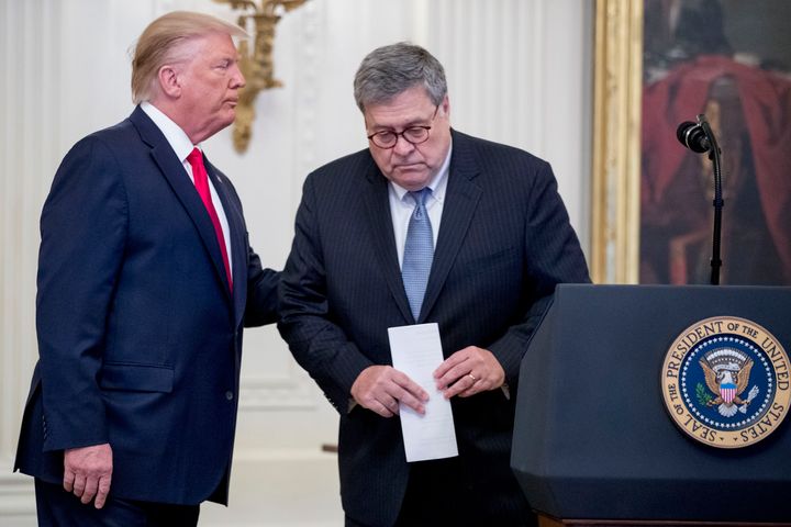 President Donald Trump, left, pats the back of Attorney General William Barr, right, as he takes the podium to present the Medal of Valor to six police officers for stopping a mass shooter in Dayton, Ohio, and Heroic Commendations to five civilians for their heroism during the mass shooting in El Paso, Texas, in the East Room of the White House in Washington, Monday, Sept. 9, 2019.