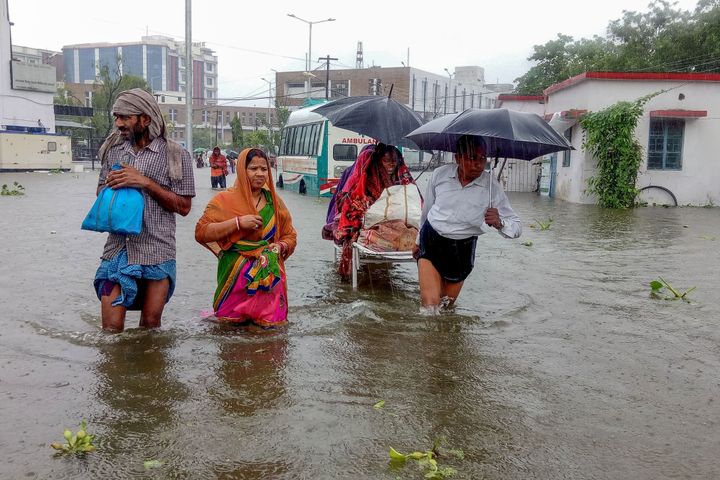 TOPSHOT - Patients wade through floodwaters on their way to hospital during heavy monsoon rain in Patna in the northeastern state of Bihar on September 28, 2019. (Photo by Sachin KUMAR / AFP) (Photo credit should read SACHIN KUMAR/AFP/Getty Images)