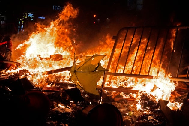 An umbrella burns after protesters set fire on steel barricades at a main street in Hong Kong. (AP Photo/Vincent Yu)