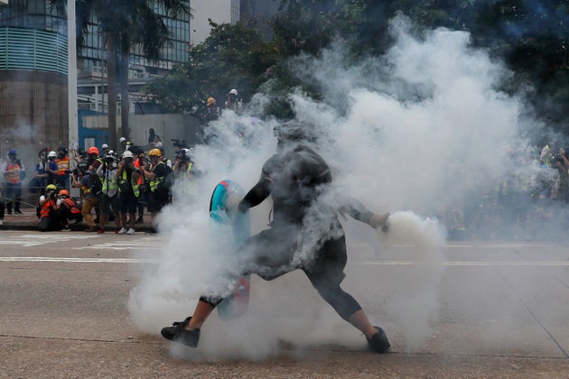 A protester throws a tear gas round back at police during the demonstration in Hong Kong. (AP Photo/Kin Cheung)