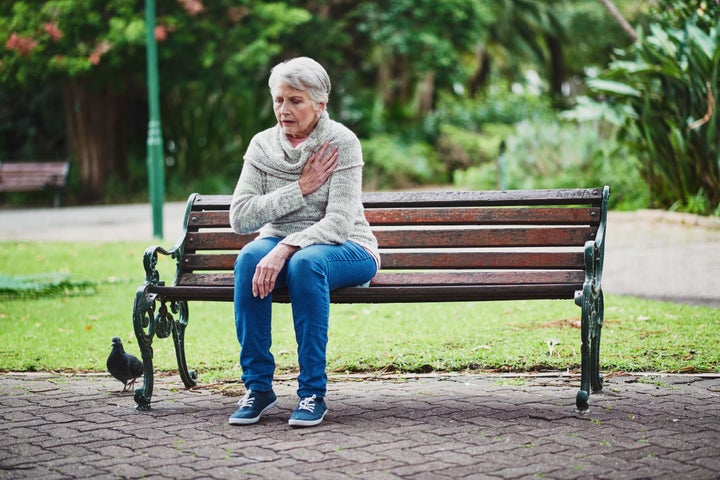 Shot of a senior woman suffering from a heart attack in the park