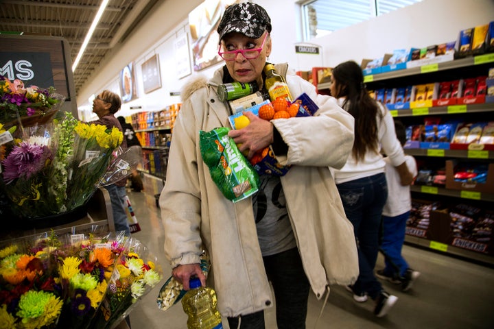 Janelle Myers fills her arms with groceries during the grand opening of Aldi food market on March 24, 2016 in Moreno Valley, California.