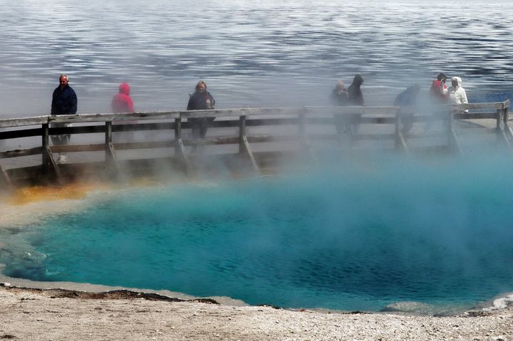 Tourists walk beside a hot spring at the West Thumb Geyser Basin in the Yellowstone National Park. Park officials said a man fell into a thermal hot spring and suffered severe burns on Sunday.
