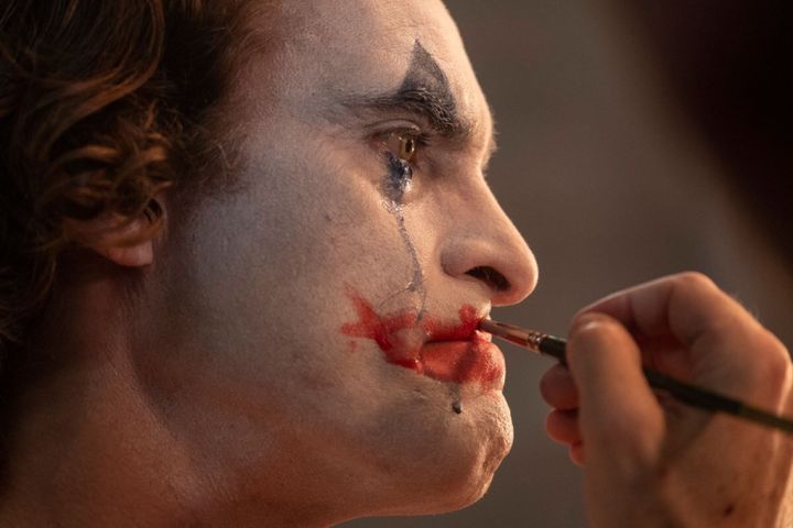 Joaquin Phoenix applies his makeup in "Joker."