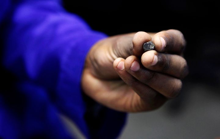 A Zimbabwean worker holds a piece of rough diamond from the country's Marange diamond fields. Rough diamonds from the diamond fields were detained by federal agents on Monday under suspicions that they were mined from forced labor.