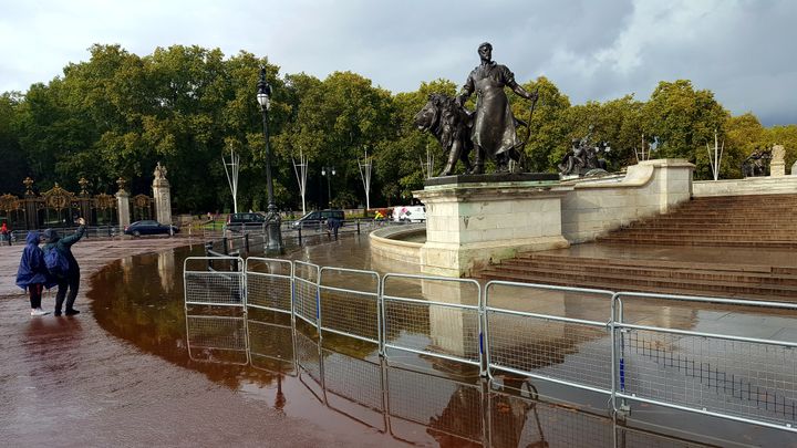 Tourists take a selfie by a flooded Queen Victoria Memorial outside Buckingham Palace, London after torrential rain hit the capital. (Photo by Teilo Colley/PA Images via Getty Images)