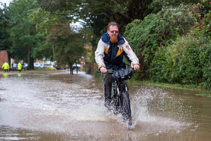 A man cycles through floodwater in Cossington, Leicester after torrential thunderstorms and the village's proximity to the River Soar has seen parts of the village flooded. (Photo by Joe Giddens/PA Images via Getty Images)