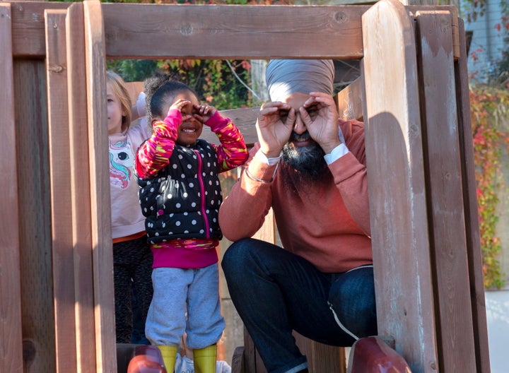 NDP Leader Jagmeet Singh and a young girl imitate the cameras as they stand on a play structure during a campaign stop at Hastings Park Childcare in Vancouver on Monday, Sept. 30, 2019.