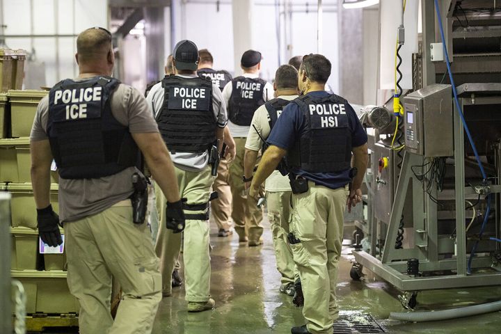Homeland Security Investigations (HSI) officers from Immigration and Customs Enforcement (ICE) look on after executing search warrants and making arrests at an agricultural processing facility in Canton, Mississippi, on Aug. 7.