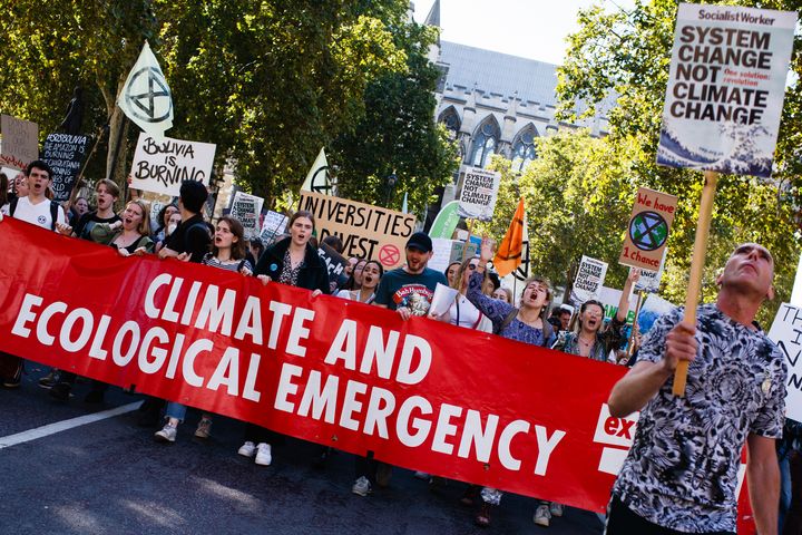 Extinction Rebellion activists group hold a banner and placards at a climate strike in London 