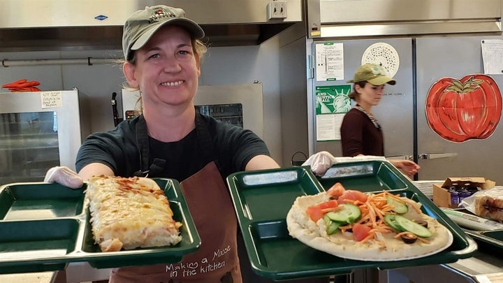 Portland, Maine, school cafeteria worker Alison Mason shows off lunch options at East End Community School, including traditional pizza, left, and vegan pizza with hummus and vegetables. More schools are adopting vegan lunches, but a bill to allocate $3 million for plant-based lunch options is stalled in the California legislature. 