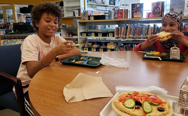 Amari Brent, left, and Rahaf Hlail, both fifth-graders at East End Community School in Portland, Maine, check out the vegan pizza, foreground. The school’s cafeteria is the first in Portland to serve a vegan option. About 14% of school cafeterias across the country now serve veggie lunches. 