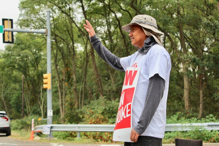 Joel Inocencio waves to a supporter outside the Langhorne GM facility.