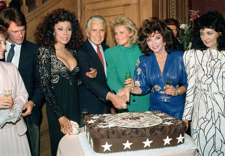 Cast members of "Dynasty" cut a cake to commemorate the production of 150 episodes of the television series in Los Angeles, Ca., Sept. 24, 1986. From left are, Diahann Carroll, John Forsythe, Linda Evans, Joan Collins and executive producer Esther Shapiro. (AP Photo/Reed Saxon)