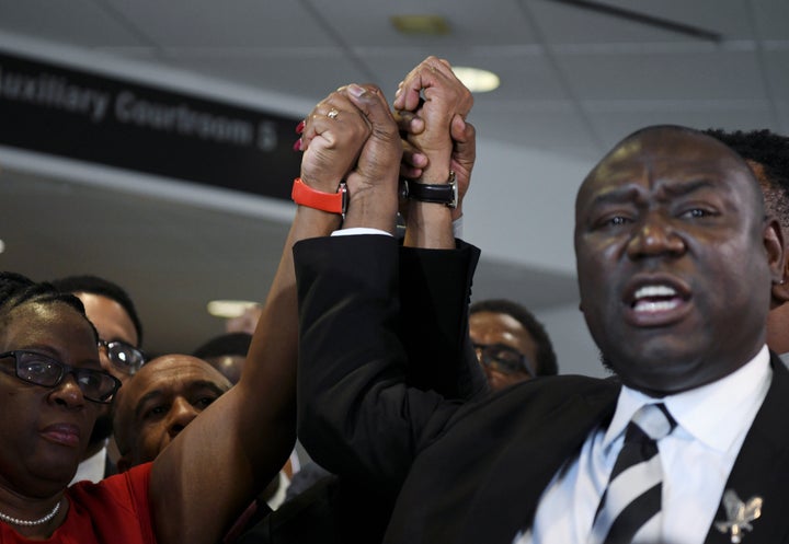 Botham Jean's mother, Allison Jean, and his father, Bertram Jean, raise their hands with their family attorneys Daryl Washing