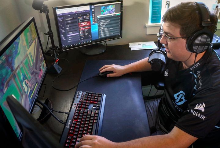In this Sept. 11, 2018 file photo, Nick Overton, a professional video game player, plays "Fortnite" while engaging with his fans online from the game room at his home, in Grimes, Iowa.