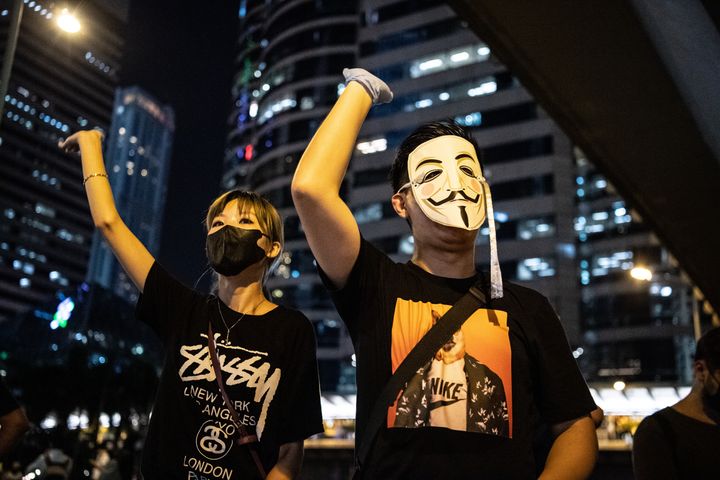 顔を隠したデモ参加者たち