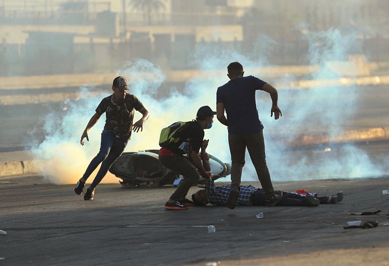 <strong>Anti-government protesters rush to an injured protestor during a demonstration in Baghdad, Iraq, Saturday.</strong>