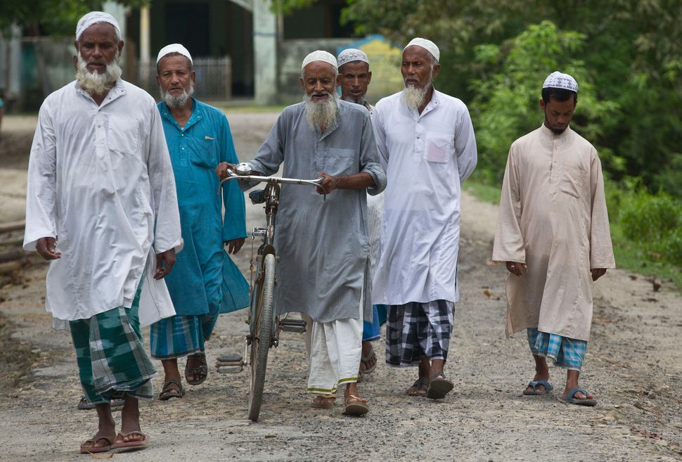 Villagers walk towards a National Register of Citizens (NRC) center to check their names on the final list in Pabhokati village in Morigaon district, in the northeastern Indian state of Assam, Saturday, Aug. 31, 2019. 