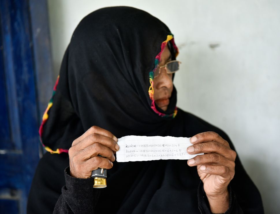 A Muslim woman shows ARN numbers written in a paper slip of her family members as she waiting to check their names in the published final list of the NRC in Morigaon district of Assam, India on 31 August 2019. 