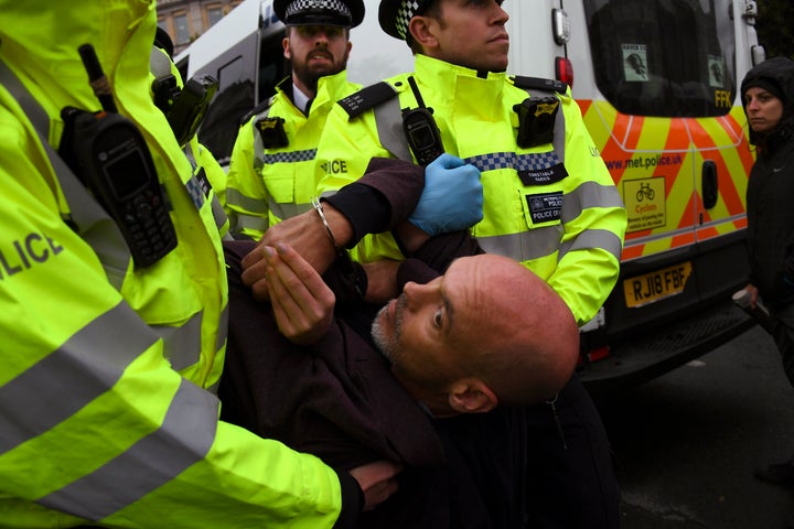 Police arrest a climate activist during an Extinction Rebellion protest in London, Monday, Oct. 7, 2019. London Police say some 135 climate activists have been arrested as the Extinction Rebellion group attempts to draw attention to global warming. Demonstrators playing steel drums marched through central London on Monday as they kicked off two weeks of activities designed to disrupt the city. (AP Photo/Alberto Pezzali)