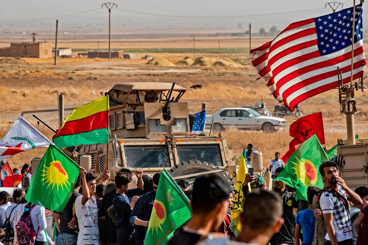 Κούρδοι της Συρίας διαμαρτύρονται μπροστά από τεθωρακισμένο όχημα των ΗΠΑ κατά της τουρκικής εισβολής. 