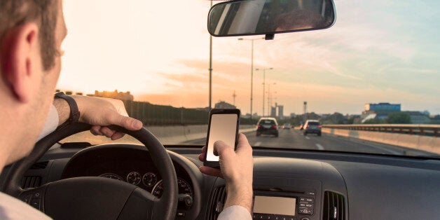 Man using cell phone while driving the car