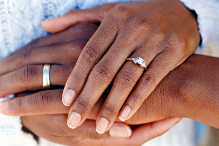 Hands of married couple wearing wedding rings