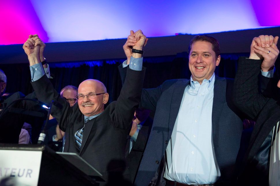 Conservative Leader Andrew Scheer, right, raises the arms with Richard Lehoux, left, candidate in the Beauce riding on Nov. 3, 2018 in St-Elzear Que.