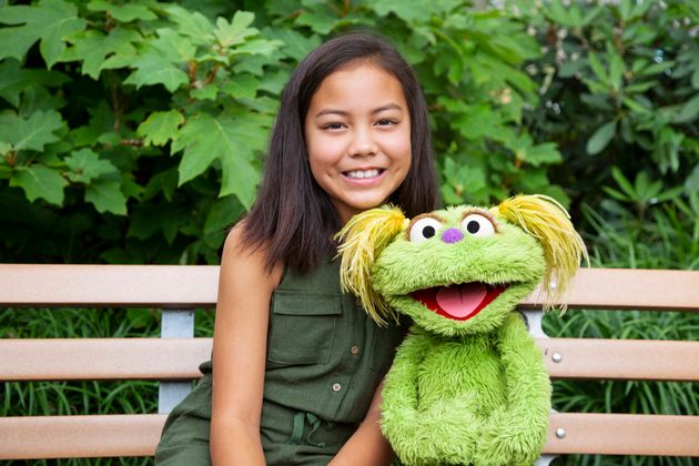 Salia Woodbury, 10, whose parents are in recovery, with Sesame Street character Karli. Together they are addressing the issue of addiction 