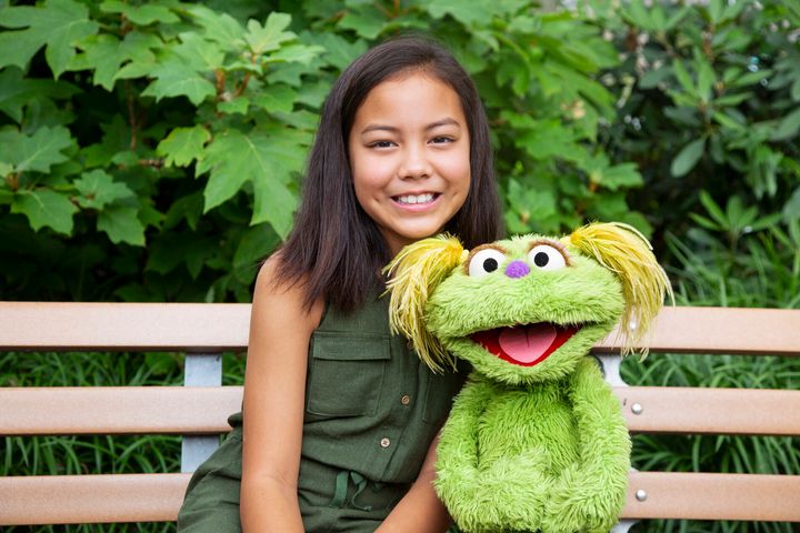 Salia Woodbury, 10, whose parents are in recovery, with Sesame Street character Karli. Together they are addressing the issue of addiction 