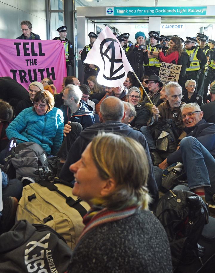 Activists stage a 'Hong Kong style' blockage of the exit from the Docklands Light Railway to City Airport, London, during an Extinction Rebellion (XR) climate change protest.