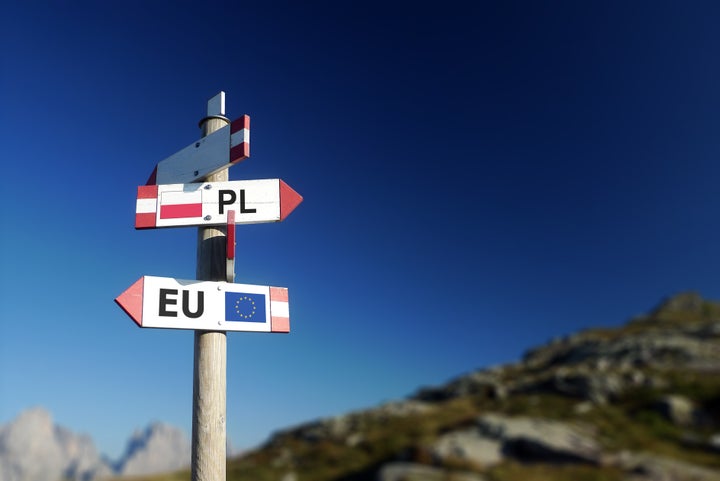 Poland and European Union flag in two directions on road sign. Diplomatic crisis