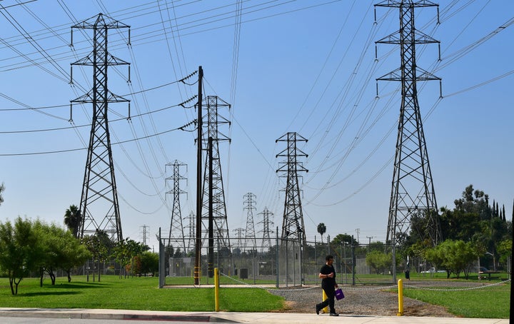 A pedestrian walks past a row of power lines in Rosemead, California, on October 9, as southern California braces for potentially widespread power outages. (Photo by Frederic J. BROWN / AFP) (Photo by FREDERIC J. BROWN/AFP via Getty Images)