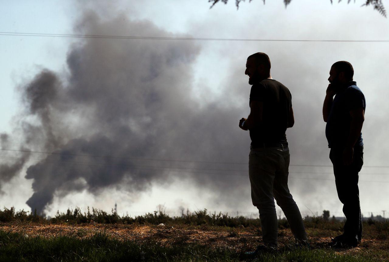 People in south-east Turkey watch smoke billowing from targets inside Syria, during bombardment by Turkish forces