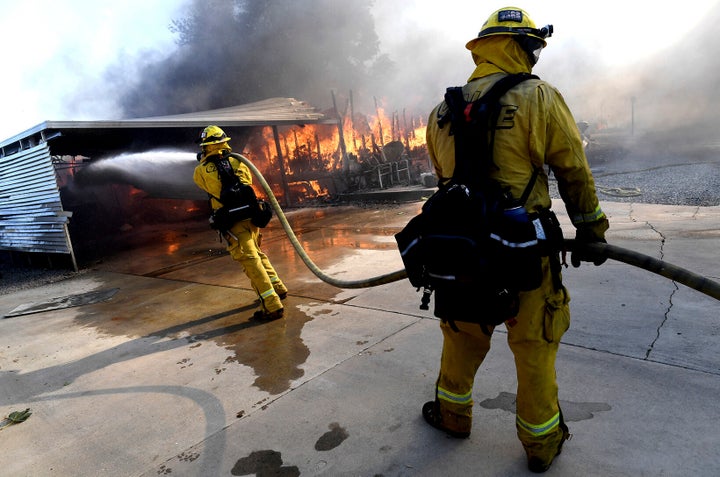 Firefighters try to protect surrounding homes as they battle the Sandalwood Fire in the Villa Calimesa Mobile Home Park in Calimesa, Calif., on Oct. 10, 2019. 