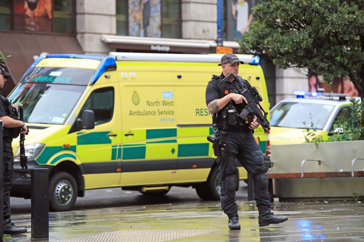 An armed police officer outside the Arndale Centre in Manchester where at least four people have been treated after a stabbing incident.