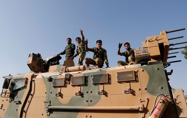Αντάρτες του Συριακού Εθνικού Στρατού (πιο γνωστού ως Εθνικού Απελευθερωτικού Στρατου της Συρίας) στέκονται πάνω σε τουρκικό άρμα μάχης, στην επαρχία της Σανλιούρφα, στα σύνορα Τουρκίας - Συρίας. 11 Οκτωβρίου 2019.