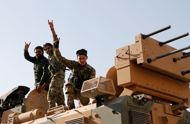 Αντάρτες του Συριακού Εθνικού Στρατού (πιο γνωστού ως Εθνικού Απελευθερωτικού Στρατου της Συρίας) στέκονται πάνω σε τουρκικό άρμα μάχης, στην επαρχία της Σανλιούρφα, στα σύνορα Τουρκίας - Συρίας. 11 Οκτωβρίου 2019.