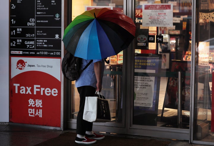 台風の影響で閉店となった店をのぞく男性