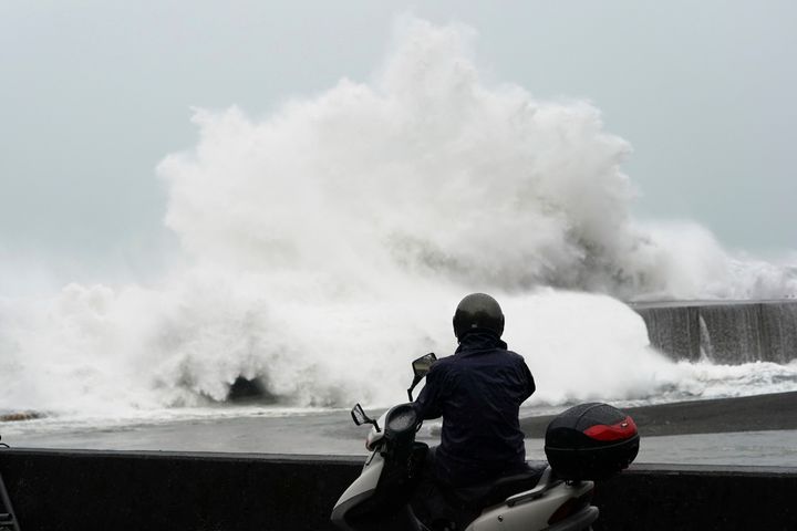 A man looks at surging waves hitting against the breakwater while Typhoon Hagibis approaches at a port in Kumano, Mie Prefecture, Japan Saturday, Oct. 12, 2019. (AP Photo/Toru Hanai)