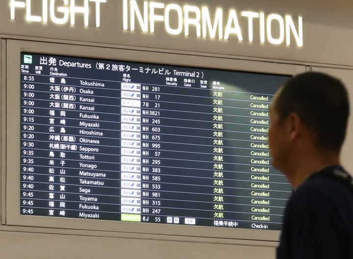 台風１９号の影響で、欠航の表示が並ぶ羽田空港出発ロビーの電光掲示板＝１２日午前、東京都大田区